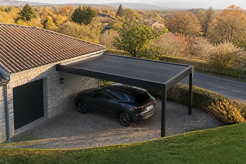 Carport en aluminium adossé à un garage, toiture en panneaux solaires